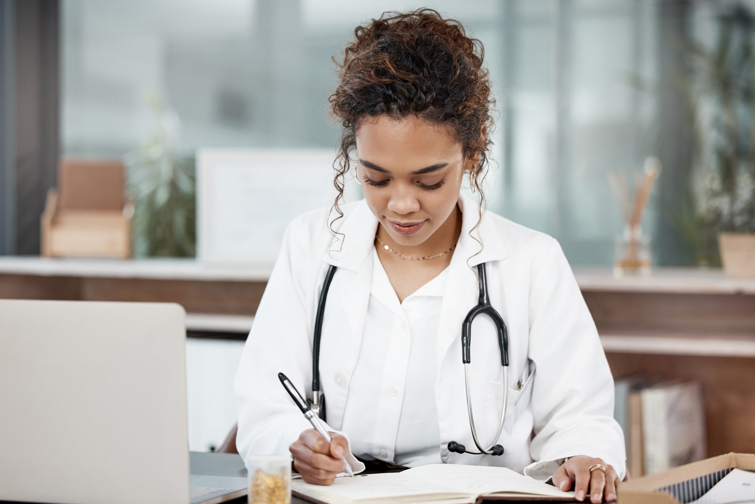 Female psychiatric mental health clinician reviewing patient records at her desk